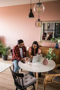 Smiling friends sitting on table