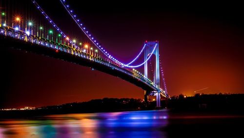 Suspension bridge over river at night