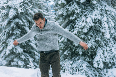 Mid adult man standing on snow covered forest