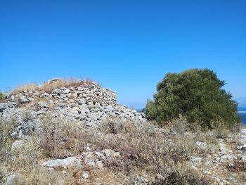 View of rocks against clear blue sky