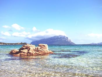 Stack rock in sea against sky