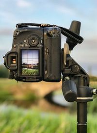 Close-up of camera on field against sky