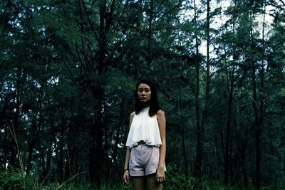 Portrait of young man standing in forest