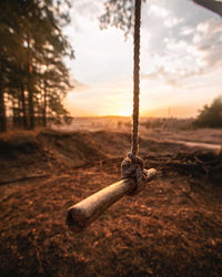 Close-up of rope on field against sky during sunset