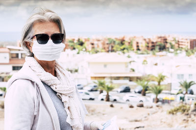 Portrait of woman wearing mask while standing outdoors