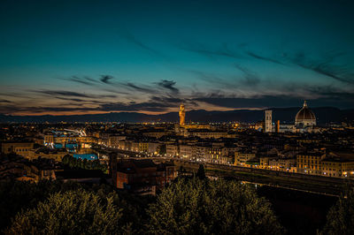Illuminated cityscape against sky at dusk