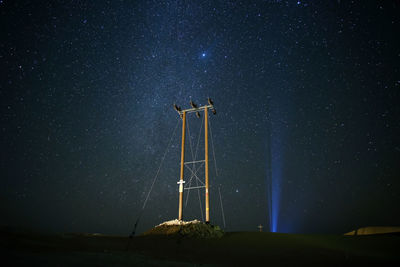Low angle view of windmill against sky at night