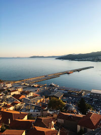 High angle view of townscape by sea against clear sky