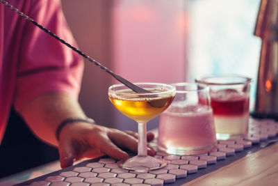 Cropped hand of bartender preparing drink in bar