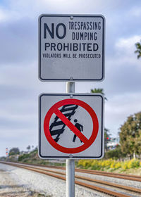 Close-up of road sign against sky