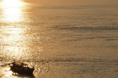 Boats in sea at sunset