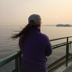 Rear view of woman looking at sea against clear sky