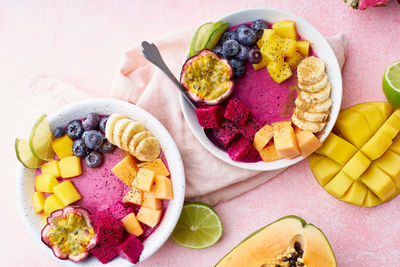 Top view smoothie bowl with dragon fruit, mango and papaya