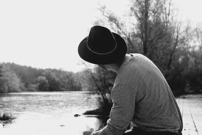 Close-up of man standing by lake against sky