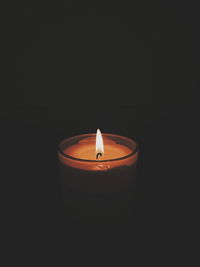 Close-up of illuminated candle against black background