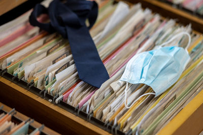 Close-up of necktie with flu mask on files