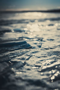 Close-up of snow on beach against sky