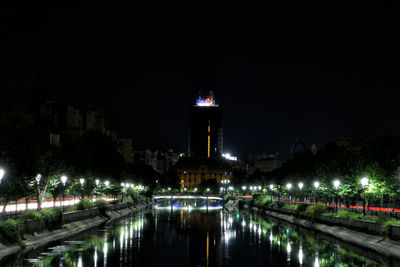 Illuminated bridge over river at night