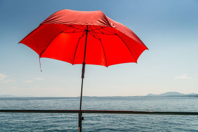 Close-up of red sunshade against sky