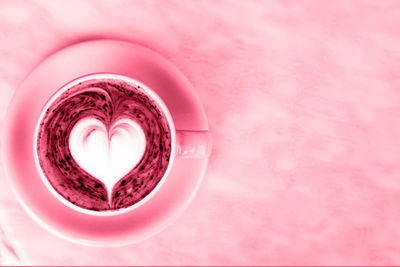 Cup of hot latte coffee on marble table background with latte art. toned on viva magenta color 