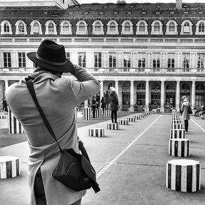 Rear view of a man with umbrella in city