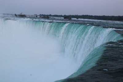 Scenic view of waterfall against sky