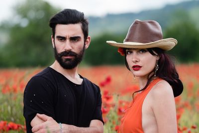 Close-up portrait of young couple standing against trees