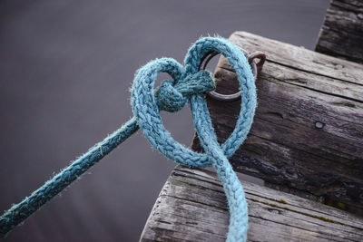 Close-up of rope tied to ring bollard on wood