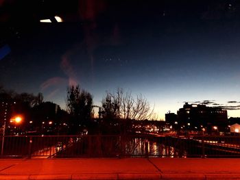 Illuminated street against sky at night