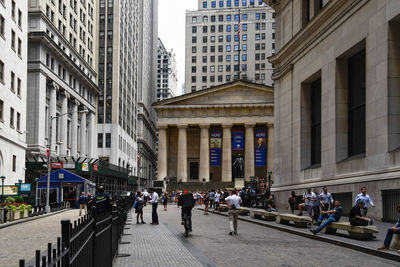 People walking on road amidst buildings in city