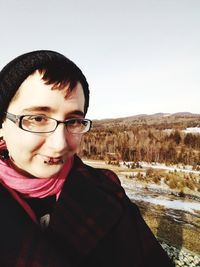 Portrait of smiling young man in mountains against sky