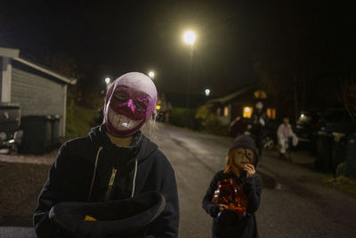 Children wearing halloween costumes posing at night