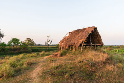 Abandoned barn on field against clear sky