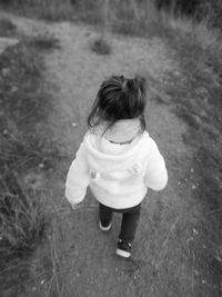 Rear view of girl walking on field