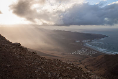 Scenic view of sea and mountains against sky