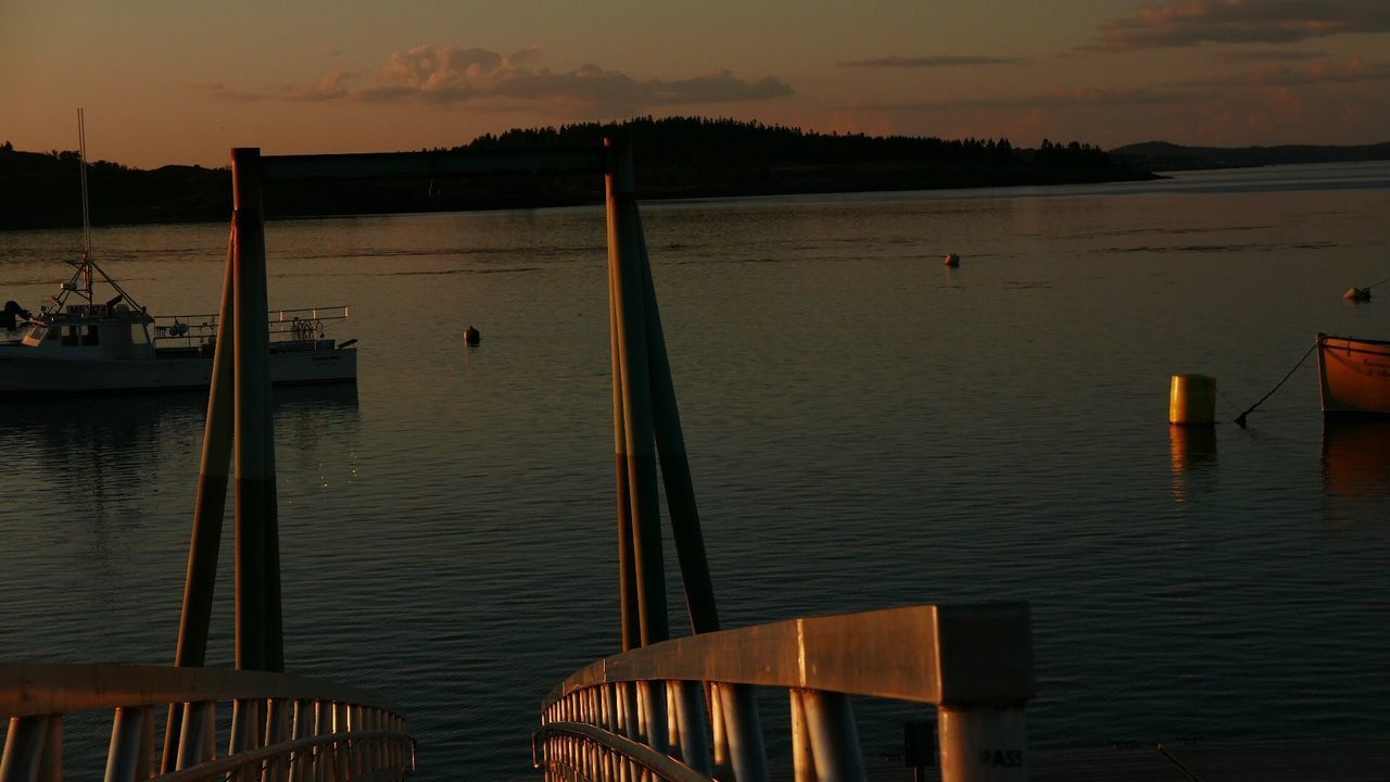 PIER ON LAKE AGAINST SKY AT SUNSET