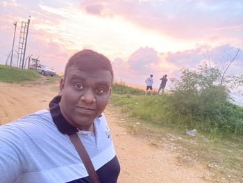 Portrait of young man against sky during sunset