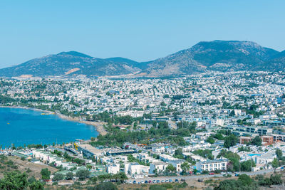 High angle view of townscape by sea against clear sky