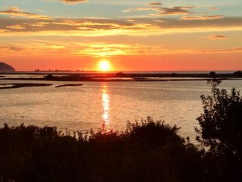 Scenic view of sea against dramatic sky during sunset