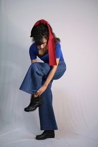 Young woman standing against wall