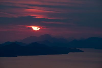 Scenic view of silhouette mountains against romantic sky at sunset