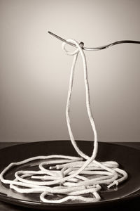 Close-up of rope on table against wall