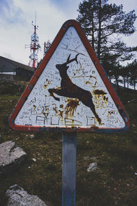 Low angle view of road sign on field against sky