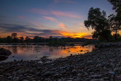 Scenic view of lake against sky at sunset