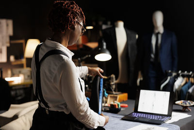 Side view of woman using laptop at office