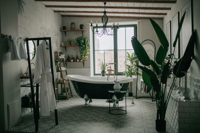 Luxury interior of big bathroom at modern african style with oval bathtub in natural lighting