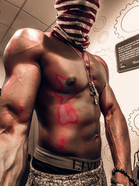 Full length of shirtless man standing at home