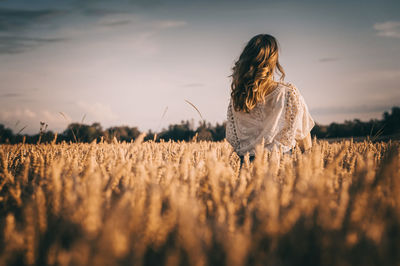 Woman standing on field against sky