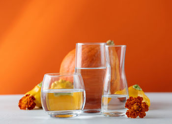 Autumn still life of pumpkins distorted through water in glasses. the concept of thanksgiving 