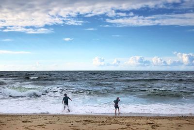 People on beach against sky